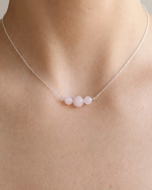 Aura No. 01 Rosenquarz Kette aus 925 Silber mit drei Rosenquarz-Perlen, getragen am Hals.