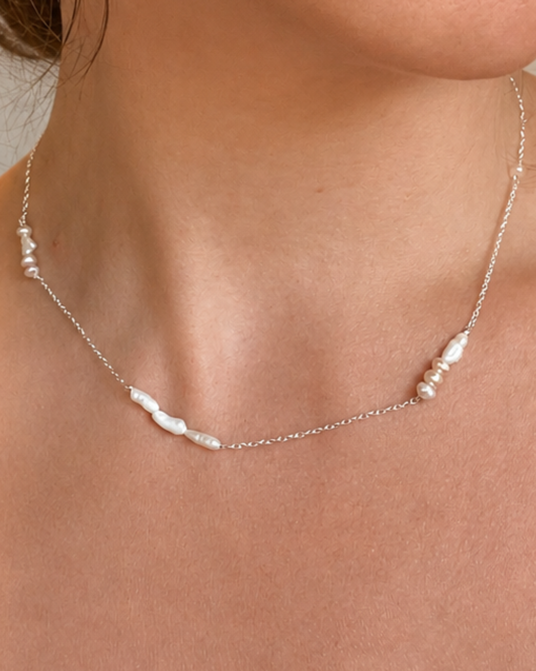 Essence No. 01 LOVE Perlenkette aus 925 Sterling Silber mit Süßwasserperlen, getragen am Hals.