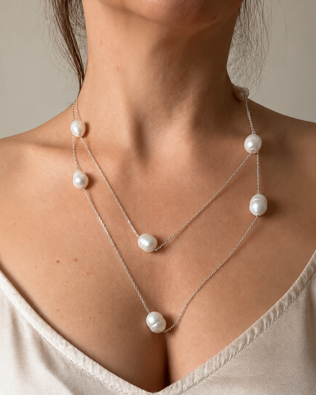 Detailaufnahme der getragenen Flow No. 01 Kette mit Naturperlen und 925 Silber zu einem Slip Dress in Ivory aus Seide.