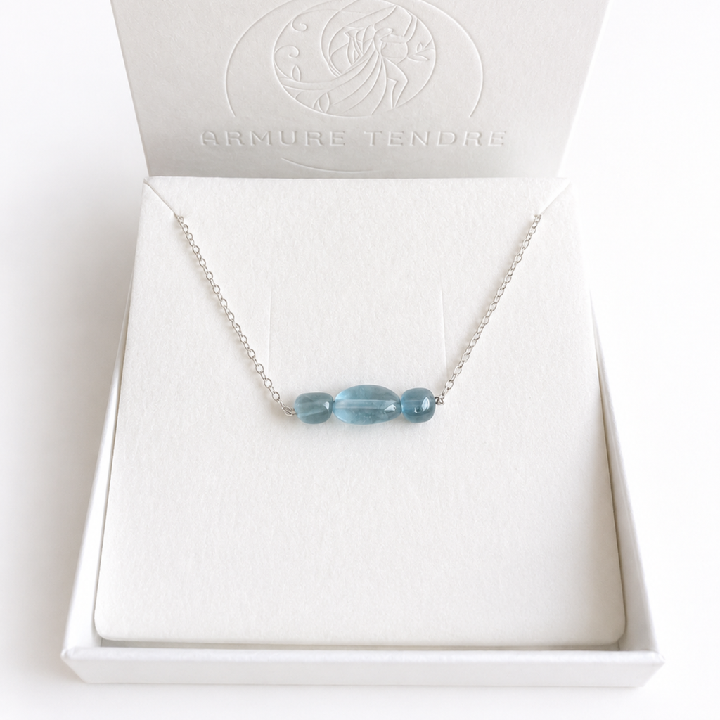 Aura aus 925 Silber mit drei blauen Aquamarinen in einer hellen Schmuckbox, als Beispiel für das Design.