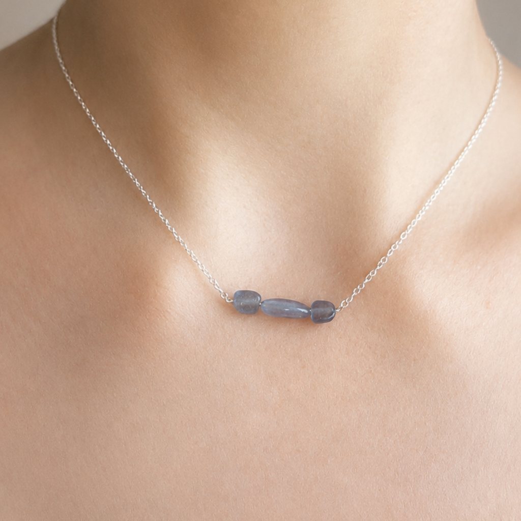 Aura aus 925 Silber mit drei blauen Aquamarinen, am Hals getragen als Beispiel für das Design.
